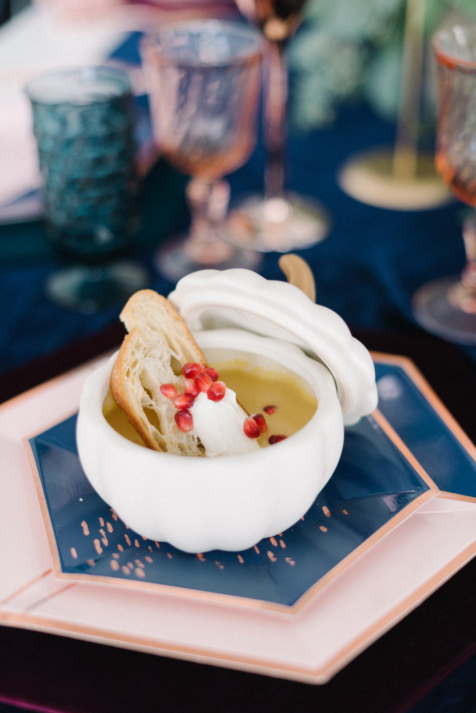 Butternut squash soup served with bread and pomegranate seeds for fall wedding