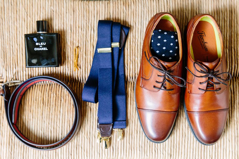 Rustic details for a fall wedding groom with leather shoes and navy blue suspenders