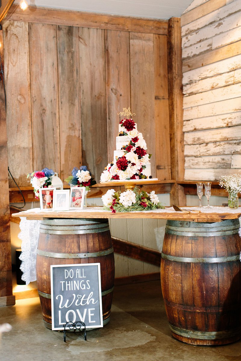 Rustic fall wedding cake on top of a wine barrel table with flowers