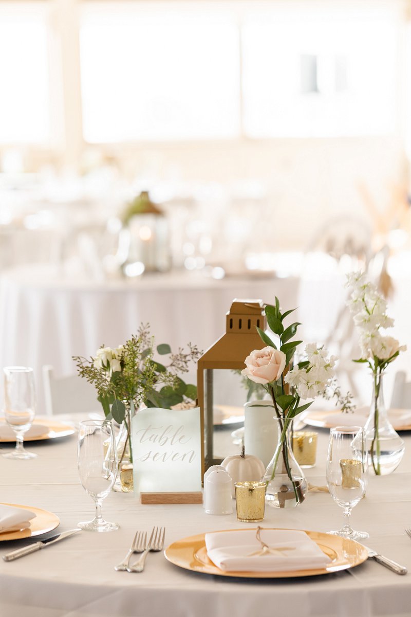 Elegant and timeless fall beach wedding reception with gold lantern and sea glass table number in the Outer Banks