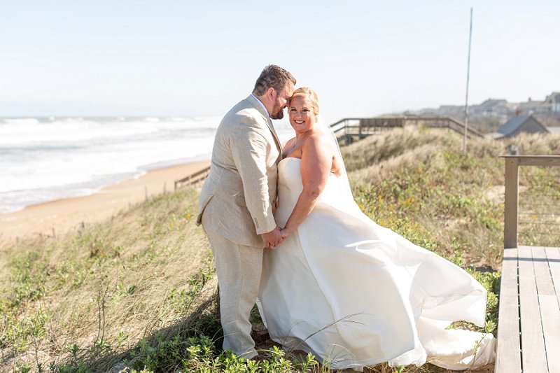 Beautiful plus size bride wearing strapless wedding dress with sweetheart neckline and full satin skirt for beachside wedding