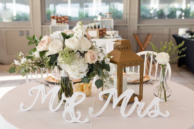 Elegant and timeless fall beach wedding reception for bride and groom table with gold lantern and bridal bouquet