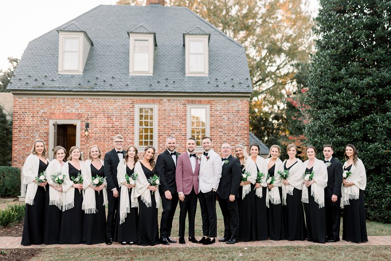 Groomsmaids and groomsmen wearing black dresses and tuxedos for modern rustic fall Virginia wedding