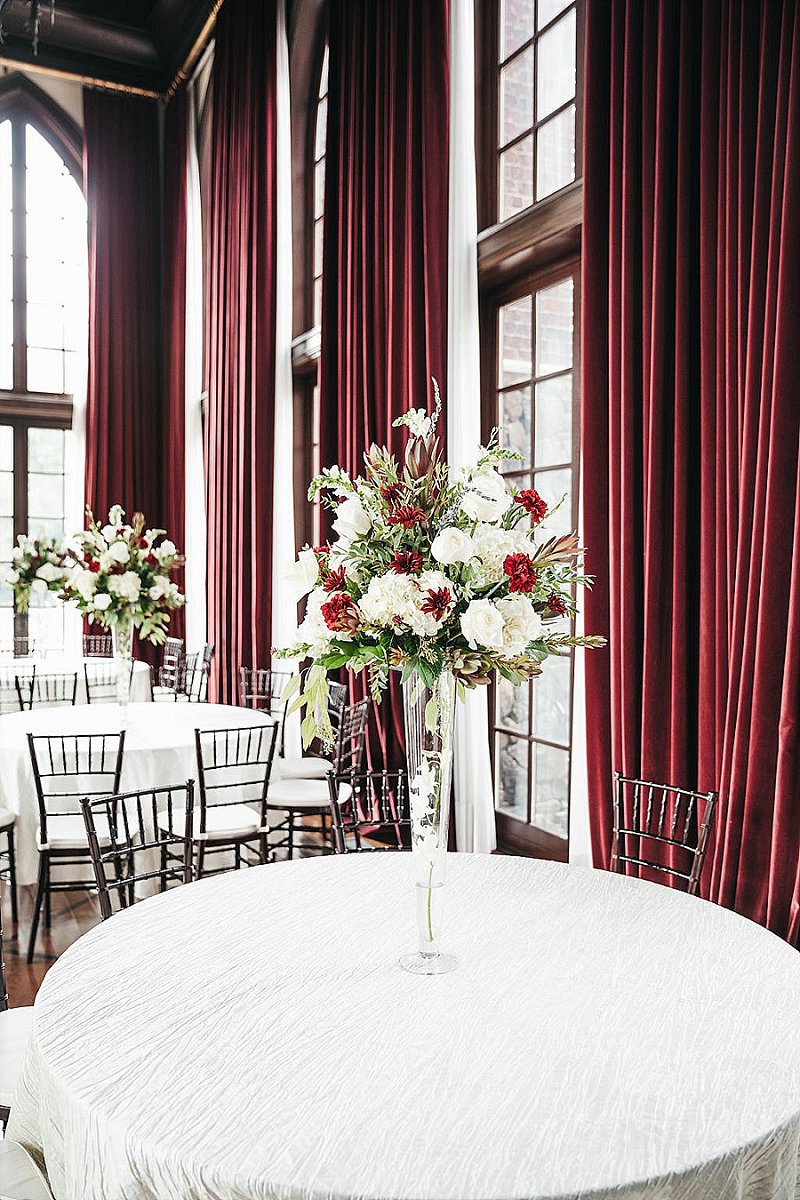 Tall wedding floral centerpieces with red and white flowers for a classic ballroom