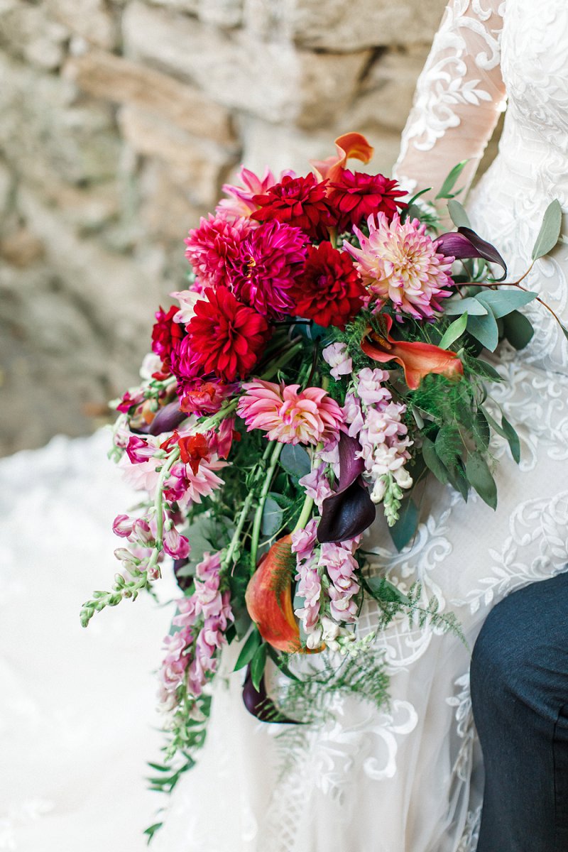 Beautiful fall inspired cascading bridal bouquet with dark pink dahlias and purple calla lilies for the ultimate dramatic jewel toned floral statement