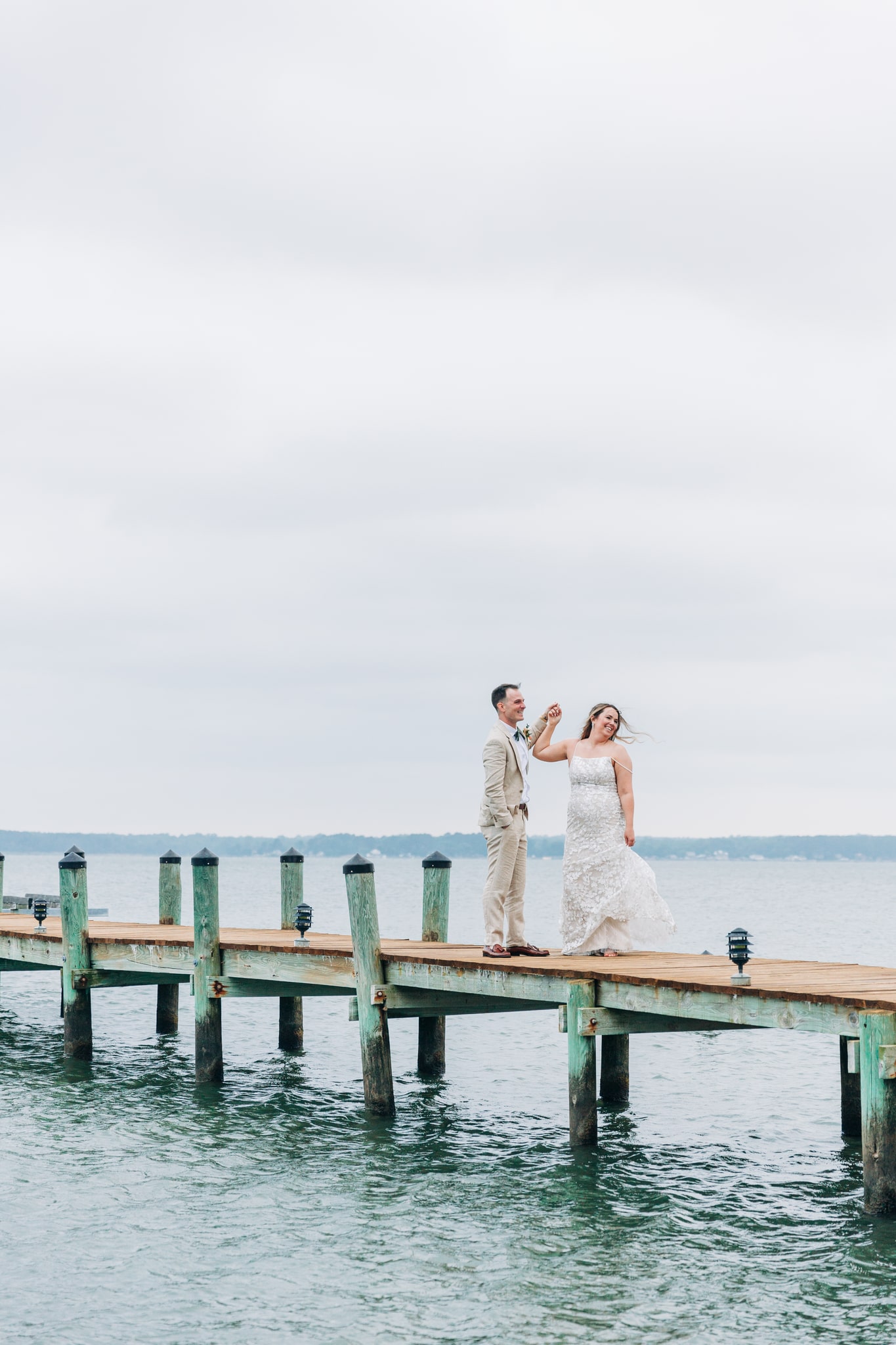 Beautiful bride and groom on a pier over the Rappahannock River for their waterside wedding