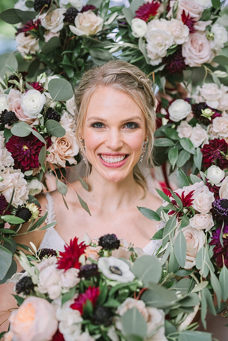 Beautiful wedding photo idea of bride surrounded by bridesmaid bouquets