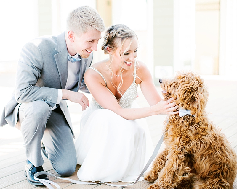 Bride and groom share a moment with their dog for their beach wedding in Virginia Beach