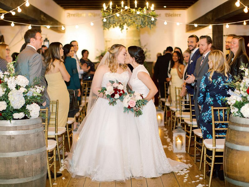 Romantic LGBTQ wedding at Williamsburg Winery in Virginia with two brides celebrating under bistro lights